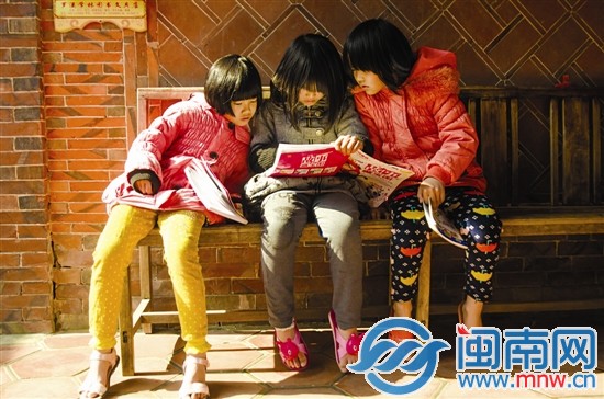 留守兒童收到捐贈(zèng)的書籍迫不及待地看起來(lái)
