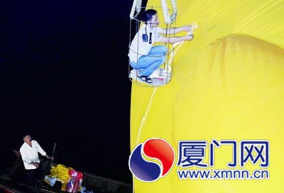 工人給大黃鴨系上繩子，準備起吊