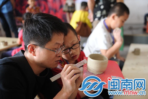 這對(duì)父子正在很用心地研究如何做陶杯