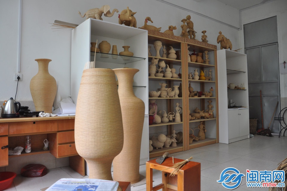 擺滿精致的竹編工藝品的櫥窗前,是即將完工的竹編工