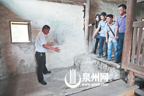 許進丁向游客們比劃著土樓墻體的厚度,當年建造土樓